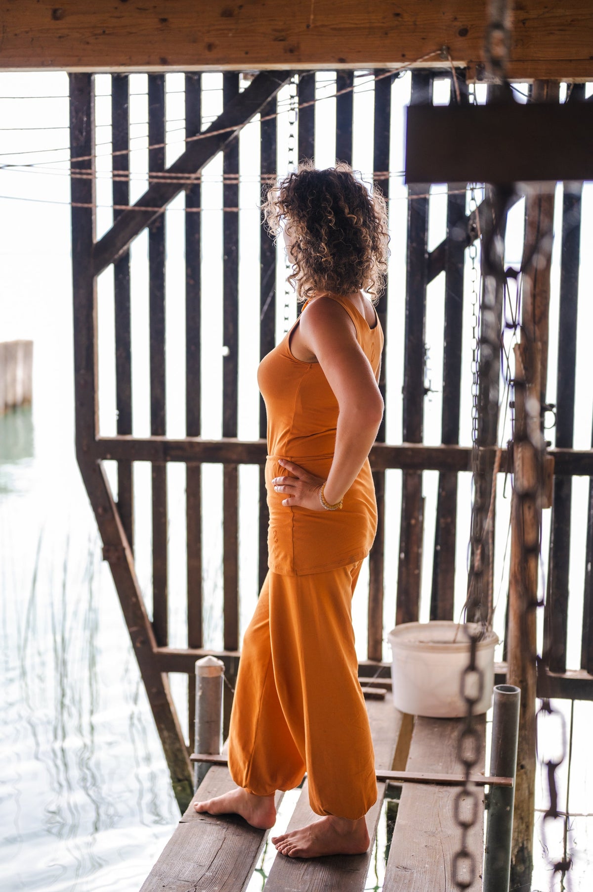 Woman in saffron Sohang yoga top and pants in organic cotton